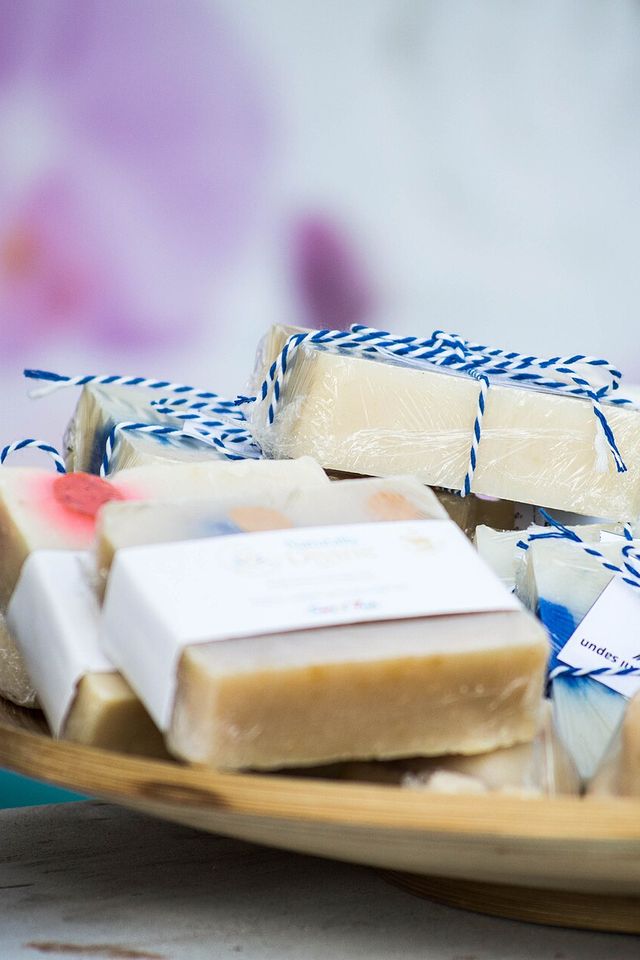 Wrapped bars of handmade soap on a wooden tray